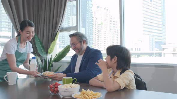 Asian family breakfast before going to work and school with Mom cooking for it.