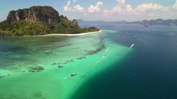 high altitude aerial of many thai longtail boats taking tourists on an island tour around the beauti alt