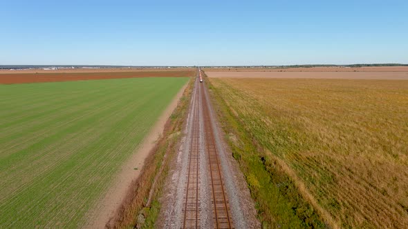 4K UHD drone aerial footage of train tracks on countryside.