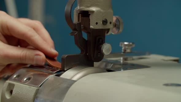 Craftsman Using Machinery Skiving Leather Piece Indoors of Workshop alt