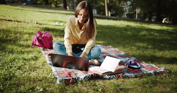 Female Student Studying in Park on Sunset