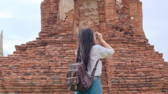 Asian woman using camera for take a picture while spending holiday trip at Ayutthaya.