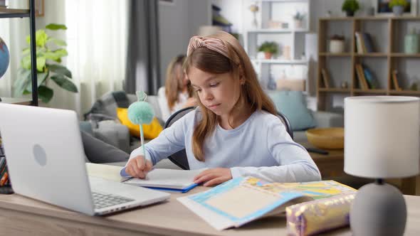 Little Girl Doing Homework at Her Desk at Home During Quarantine alt