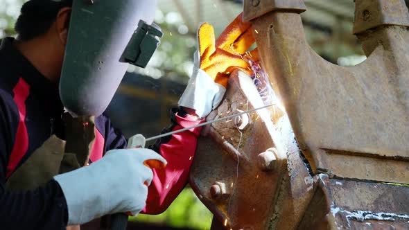 4K Asian man welder working on welding machine in construction factory. alt