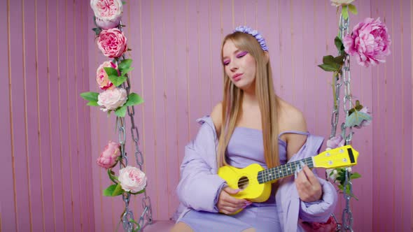 Sexy Blonde Girl Sit on Swing with Ukulele Sings alt