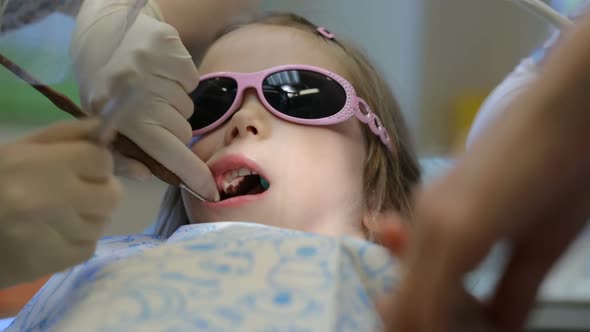 Little girl in dentist's chair having her tooth treated