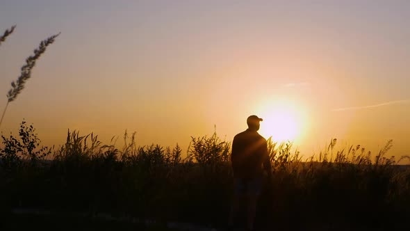 A Sad Man Looks Into The Distance Against The Backdrop Of A Beautiful Sunset alt