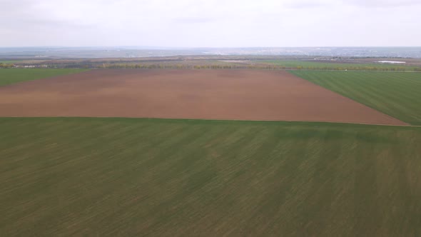 Aerial Drone Footage Approaching Farm Fields in Countryside alt