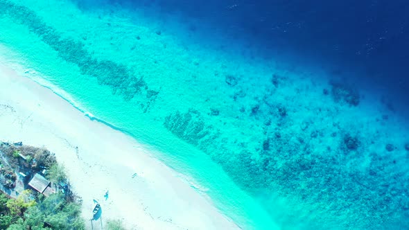 Wide angle above tourism shot of a white paradise beach and blue ocean background in colourful 4K alt