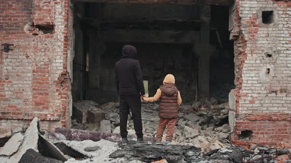 Father and Daughter Looking at Their Demolished House alt