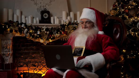 Modern Santa Claus Uses Laptop Fills in Holiday Cards Children Happy New Year alt