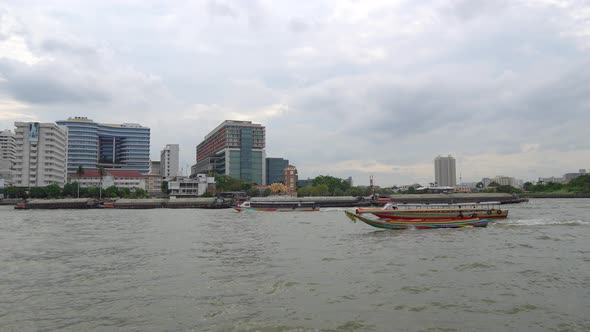 Traditional Long-Tail Boats Moving on Chao Phraya River at Downtown of Bangkok alt