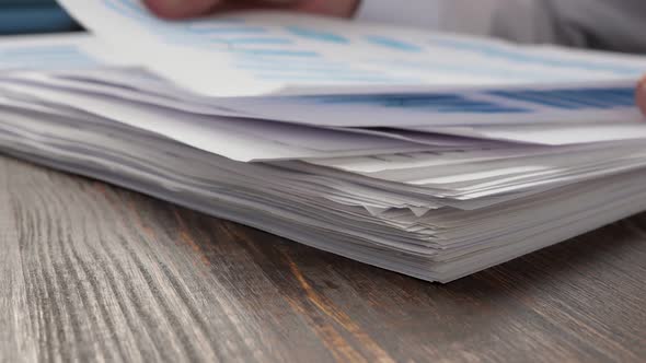 Stack of Papers with Financial Report Charts and Figures