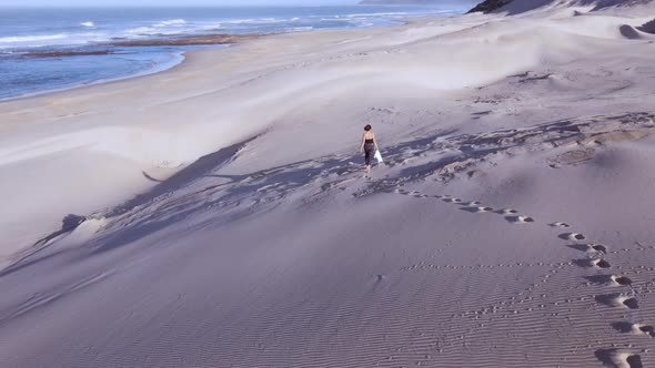 Aerial View of Woman Seen Walking Along Sand Dunes