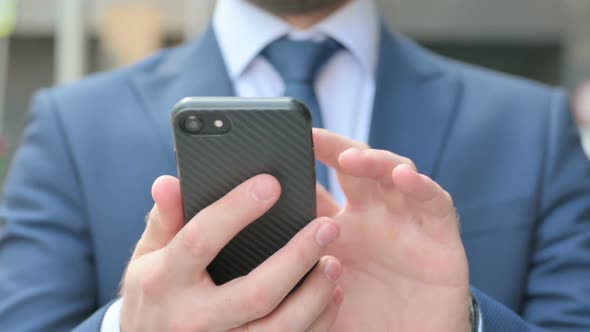 Hands Close up of Businessman using Smartphone while Standing in Street alt