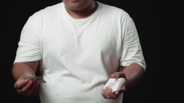 Trick Of Magician With The Card In Unusual Way, Throwing Cards, On Black Background alt