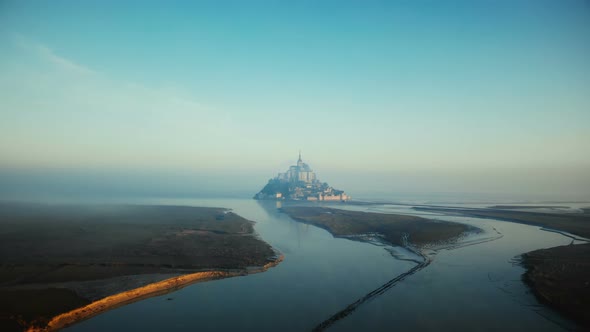 Drone Flying Towards Foggy Mont Saint Michel on Epic Sunrise High Tide, Iconic Island Fortress alt