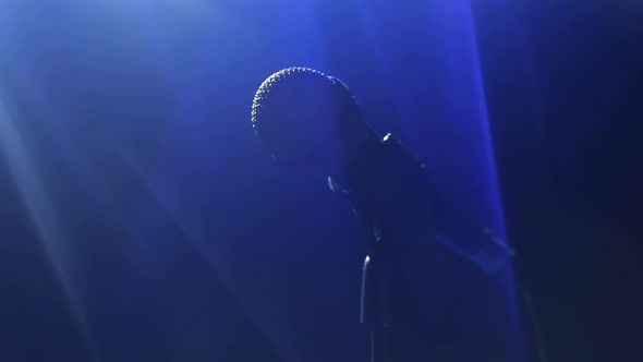 Closeup of Microphone on Stage with Blue Lighting alt