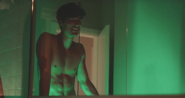 Man blows kiss for woman through mirror alt