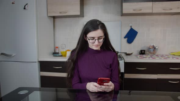 Happy Girl Using Phone at Home Chatting with Friends alt