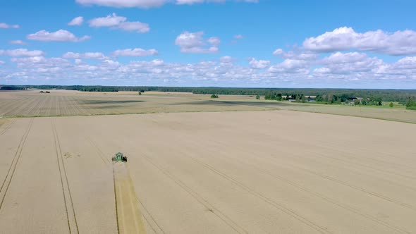 The Aerial View of the Green Harvester in the Wheat Field in Estonia
