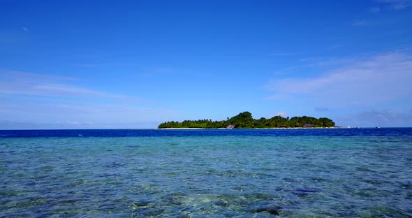 An Island In Fiji - Clear Shallow Ocean Water With Lush Island In The Background - Wide Shot alt