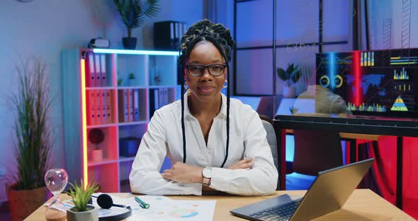 African American Businesswoman in Glasses which Gesturing Thumbs Up Into Camera in Evening Office alt