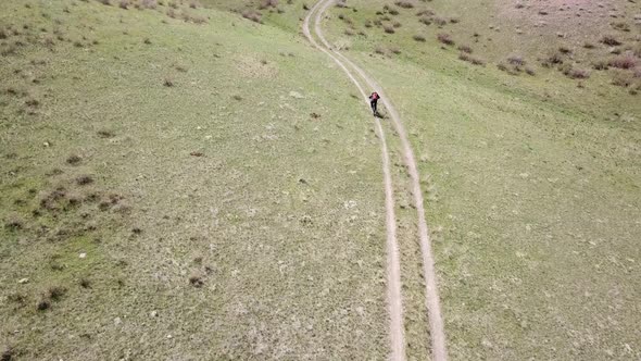 A Group of Cyclists Ride on the Green Steppe alt