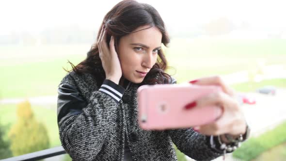 Young beautiful woman taking selfie with smart phone alt