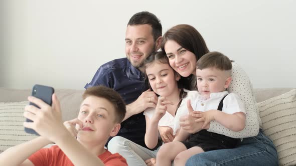 Happy Smiling Family Sitting on Sofa in Living Room alt