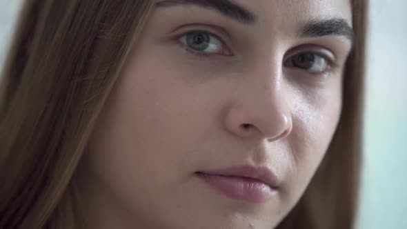 Portrait of Young Pretty Woman with Different Colored Eyes Looking at Camera in the Morning alt