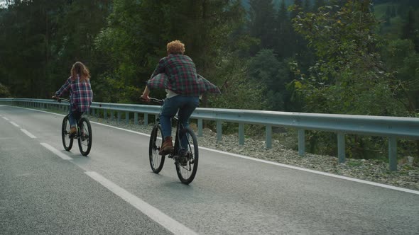 Couple Enjoying Bicycles Trip on Mountains Highway alt