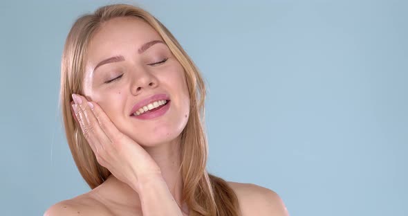 Young Beautiful Woman Bare Shoulders Portrait. Posing Isolated on Blue Background alt