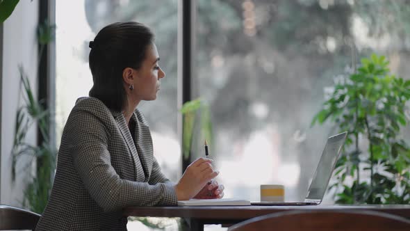 Arabian Hispanic Woman Working Financial Paperwork Seated at Workplace Using Laptop Looks alt