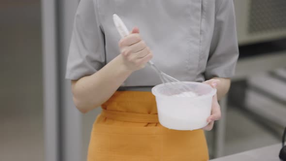 A Bright Girl Cooks Sweet Dishes at a Small Production Facility