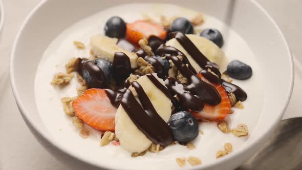 Muesli with yogurt, fresh berries and chocolate sauce