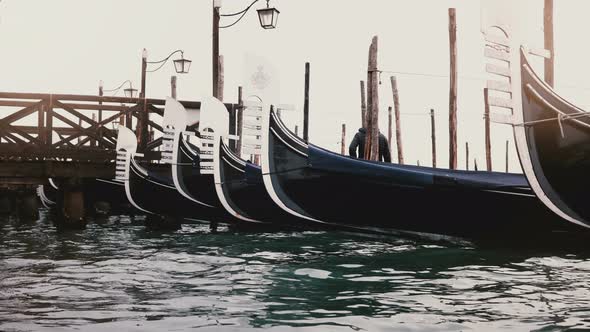Medium Shot of Beautiful Traditional Empty Gondolas Rocking on the Waves at Morning Wooden Lagoon alt