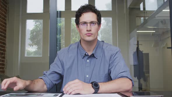 Portrait of man checking a document at office alt