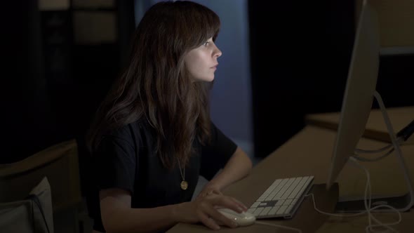 Woman Working Late at Night Looking on the Screen of Computer