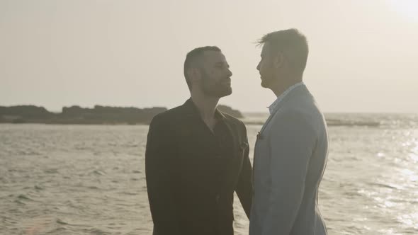 Gay couple on the beach together during sunset alt