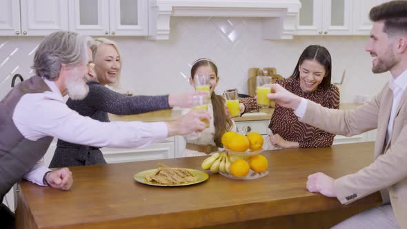 Family Clinking Glasses with Orange Juice Celebrating Together Birthday of Cute Little Girl alt