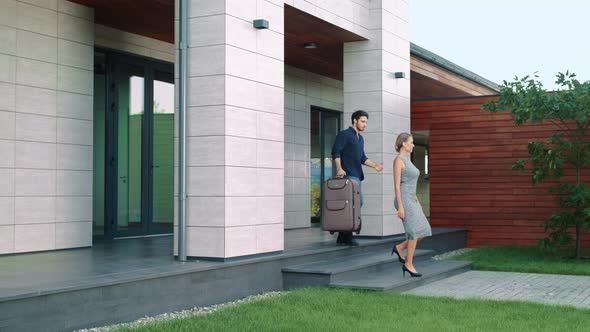 Business People with Luggage Leaving Luxury House alt