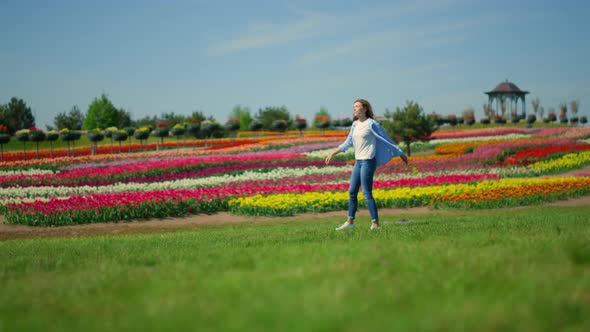 Unknown Woman in Casual Clothes Walking in Beautiful Spring Garden in Daytime alt