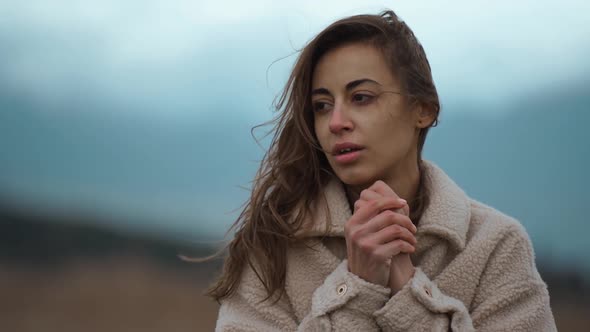 Slow Motion Close Up Face of Disappointed Ukrainian Woman Stands Outdoors at Cold Cloudy Autumn Day alt