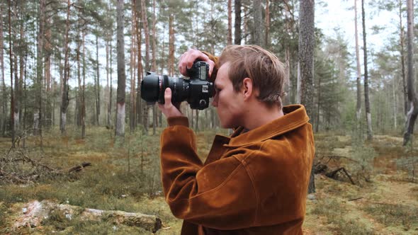 A Young Blond Male Photographer Takes Pictures of Nature alt