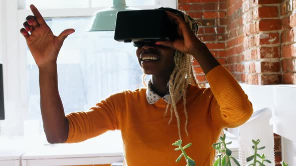 Female executive using virtual reality headset alt