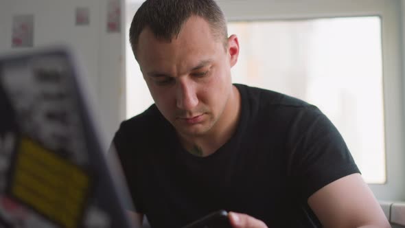 Person Looks at Cellphone and Stands Up From Desk at Home alt