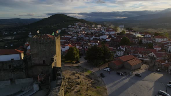 A drone flies past the tower of Belmont Castle over the roofs of the ancient town. alt