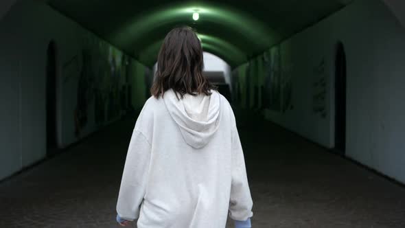 Cute Girl Walks Into Underground Tunnel Looking Into Camera