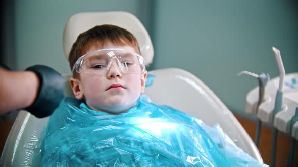 A Little Boy Having His Teeth Done - Putting on Safety Cover and Glasses alt